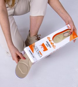 Kobiece dłonie wyciągające z opakowania wkładki do butów sportowych Coccine